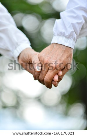 Concept shoot of friendship and love of man and woman: two hands over nature