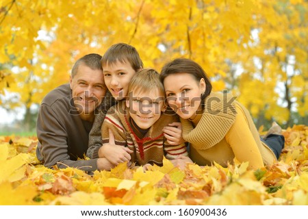 happy family on a walk during the fall of the leaves in the park