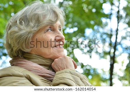 nice elderly woman walking in the park alone