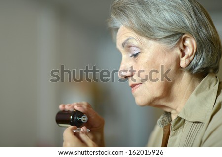 close-up portrait of an older woman taking a medicine