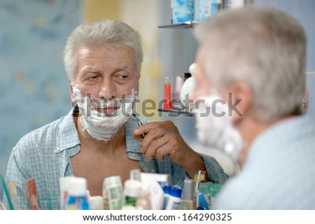 Senior man shaving in bath