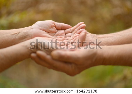 Two hands together against the natural backgrouns