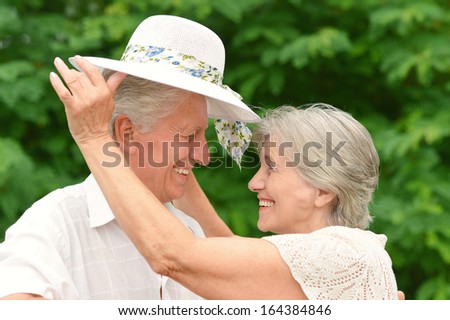 Happy old couple walks in the park in summer day