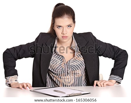Angry beautiful secretary in black dress sitting at table