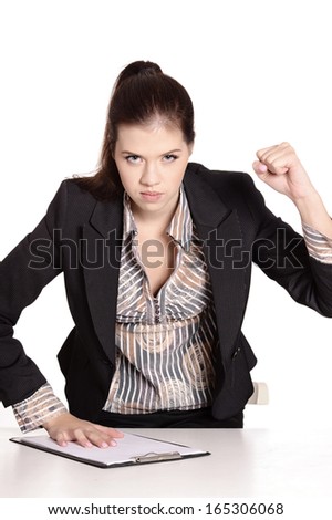 Angry beautiful secretary in black dress sitting at table