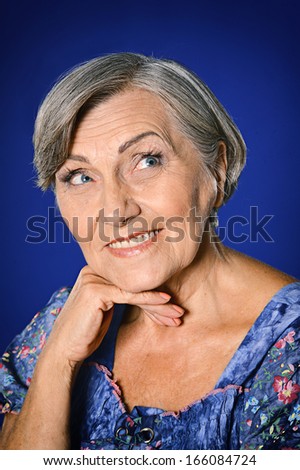 Happy smiling elder woman portrait on grey background