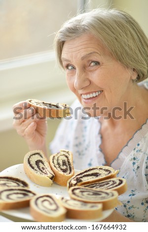 Closeup of a senior woman eating poppy pie