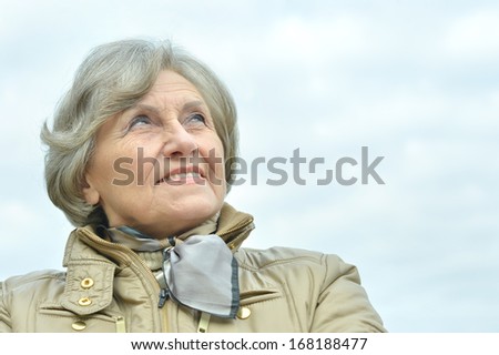 Nice elderly woman walking in the park alone
