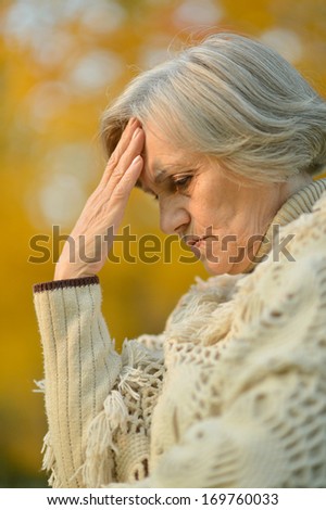 Nice sad old woman on the autumn background