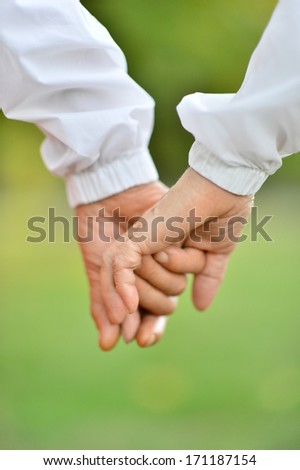 Hands held together on a natural green background