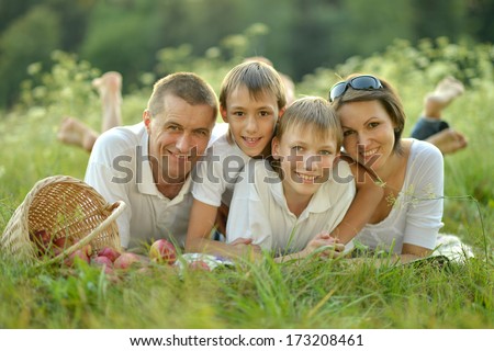 Family of four is having picnic in green summer park