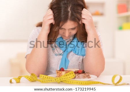 Depressed Dieting Woman With Cake And Measuring Tape