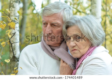 Sad senior couple in autumn birch forest
