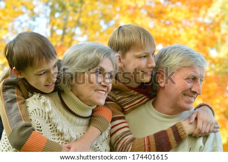 Portrait of a cute grandparents with grandchildren in fall park