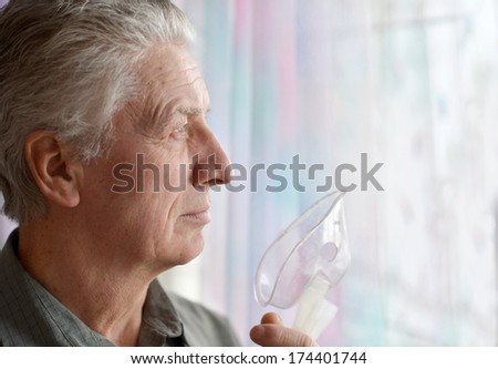 Close-up of an old man doing inhalation