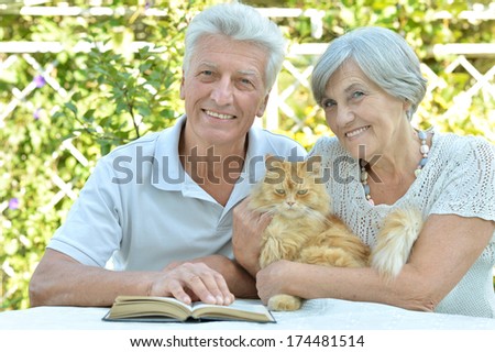 Nice Elderly Couple With Cat In A Summer Park
