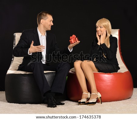 Man giving beautiful woman present on a black background