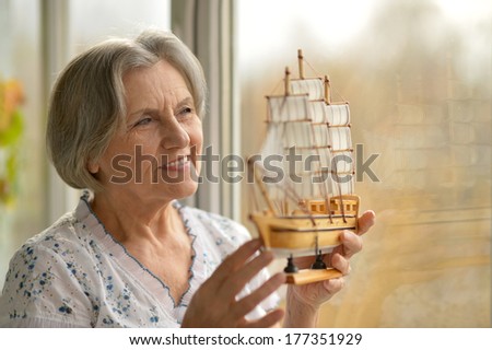 Senior woman with miniature ship