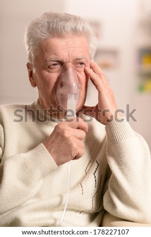 Close-up portrait of an elderly man making inhalation