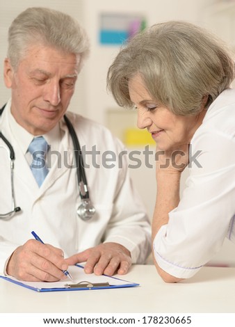 Elderly doctors working at table