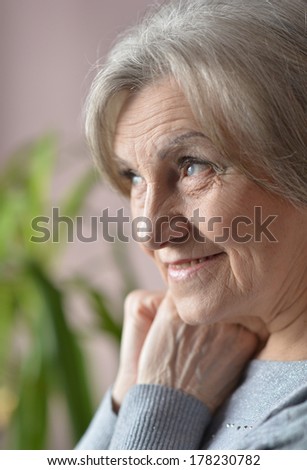 Senior woman happy at home on green background