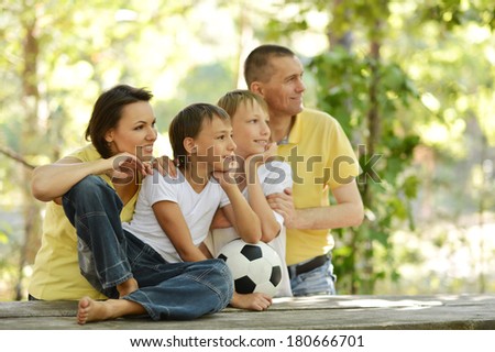 Portrait of happy family at wooden table with football ball
