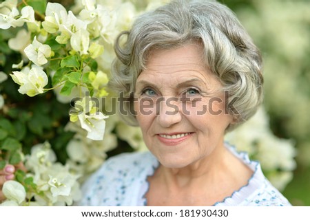 Happy elderly woman enjoying a walk in the fresh summer air