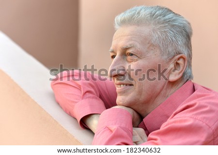 Glorious mature man on terrace in pink shirt
