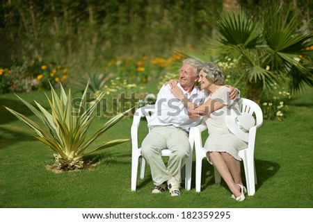 Senior couple sitting at tropic hotel garden