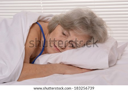 Beautiful older woman sleeping in the bedroom after a hard working week