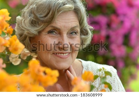 Close-up portrait of an older woman on walk with flowers