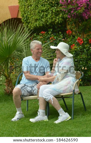 Senior couple sitting at tropic hotel garden