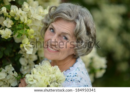 Portrait of a beautiful smiling elderly woman with white flowers