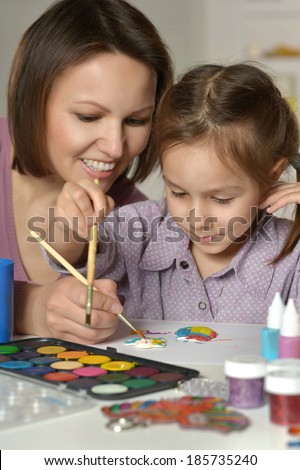 Mother and little girl painting at home