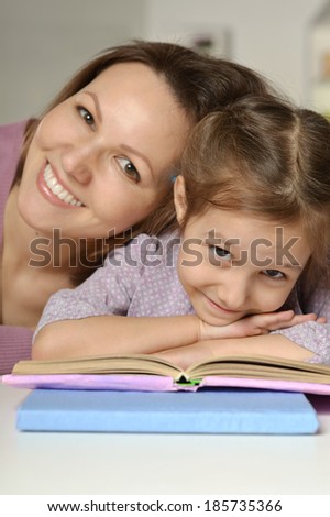 Daughter and mother read the book at home