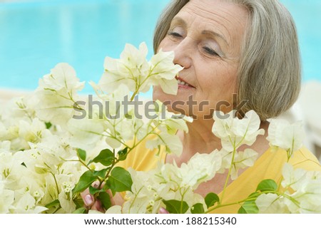 Older happy smiling woman with white flowers