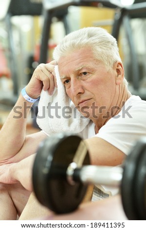 Elderly man in a gym. resting after exercise