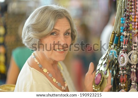 Cute smiling senior woman at souvenir store
