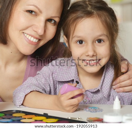 Mother and little girl painting at home