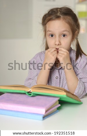 Cute thinking little girl with a book