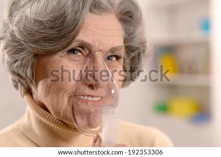 Close-up portrait of an elderly woman making inhalation