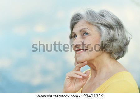 Portrait of a beautiful senior woman on the background of sky