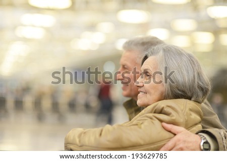 Senior couple at airport sitting on bench