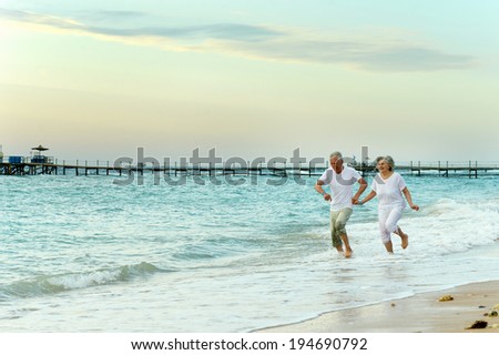 Nice old couple running on sea beach