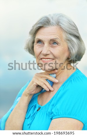 Portrait of a beautiful senior woman on the background of sky