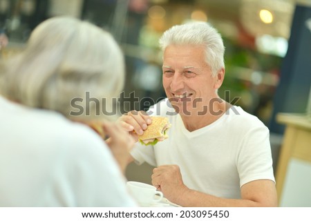 Portrait of beautiful elderly couple eating fast food