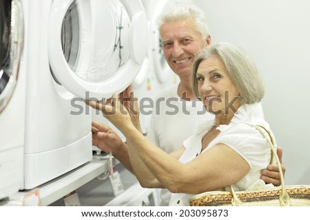 old couple in store choosing washing machine