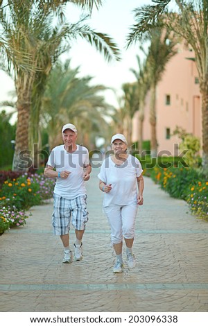 Senior couple run at tropic hotel resort