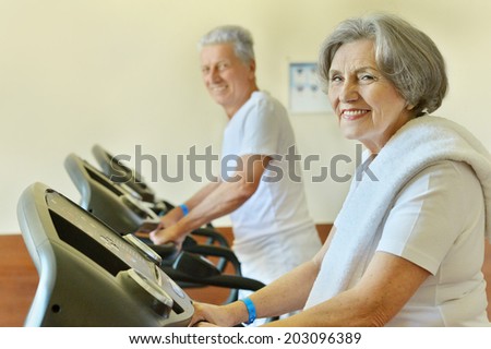 Senior couple in gym on running track