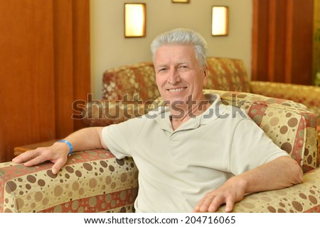 Elderly man sitting in armchair in room